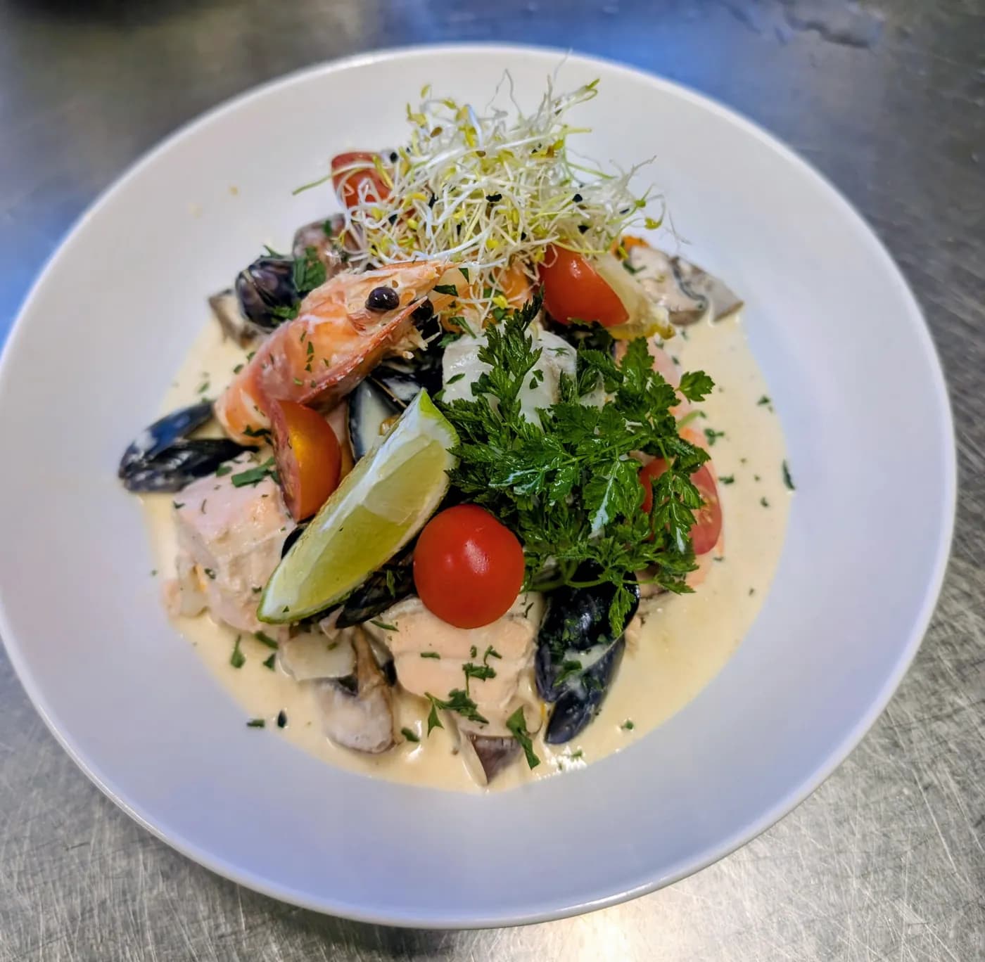 Assiette de poissons et fruits de mer dressée en cuisine à L'Azéa
